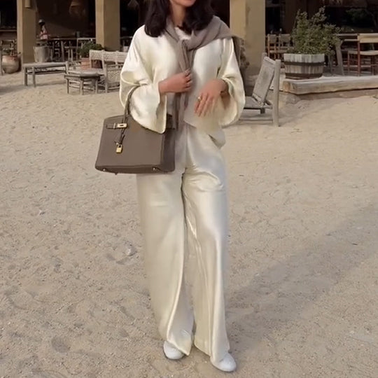 Zīdains un elegants satīna bikšu komplekts ar platu kaklu, garām piedurknēm ar brīvu augšdaļu un elastīgu vidukli.