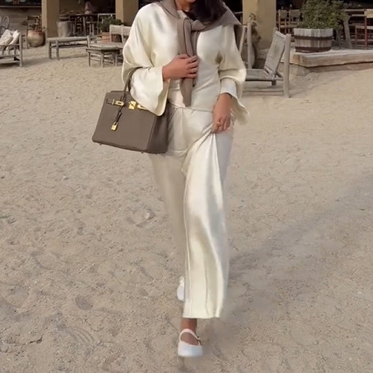 Zīdains un elegants satīna bikšu komplekts ar platu kaklu, garām piedurknēm ar brīvu augšdaļu un elastīgu vidukli.