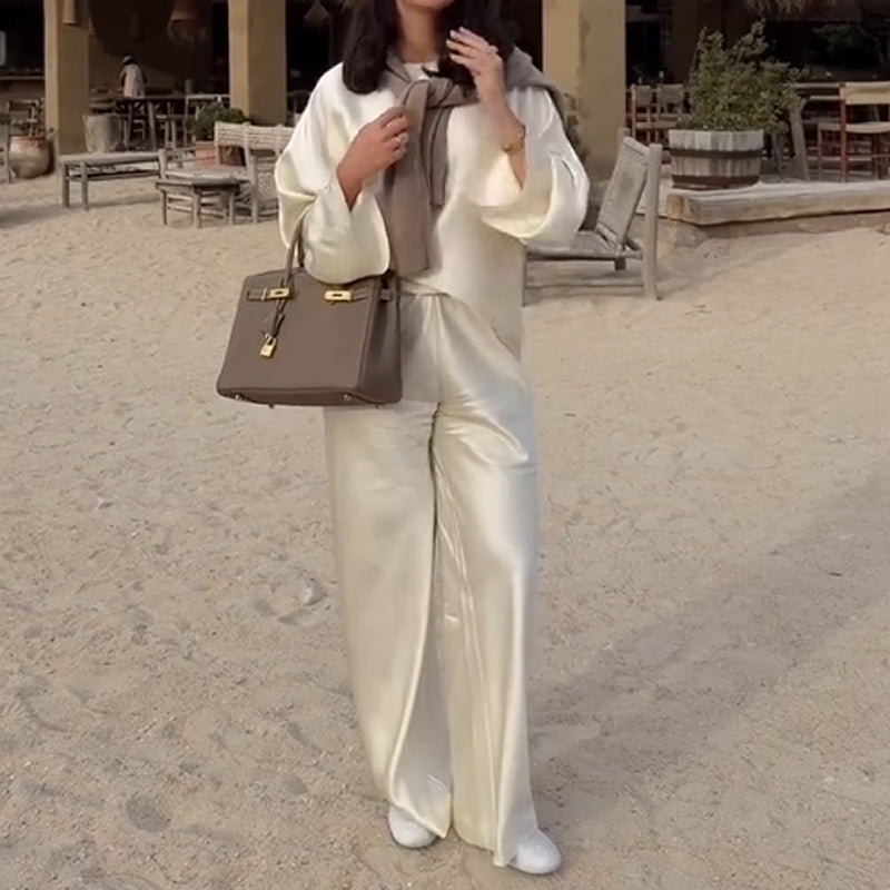 Zīdains un elegants satīna bikšu komplekts ar platu kaklu, garām piedurknēm ar brīvu augšdaļu un elastīgu vidukli.