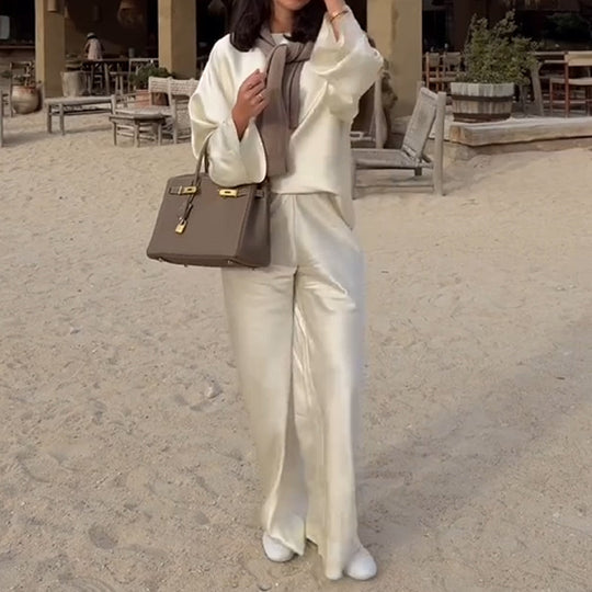 Zīdains un elegants satīna bikšu komplekts ar platu kaklu, garām piedurknēm ar brīvu augšdaļu un elastīgu vidukli.